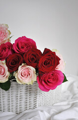 bouquet of beautiful pink and red roses in a basket