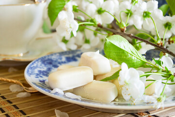 Obraz na płótnie Canvas Set of white chocolate candies, tenderness of morning coffee, with white cherry flowers