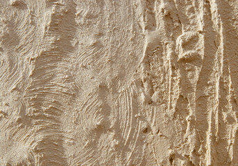 Relief texture with irregularities and clear shadows prints and lines on a beige background