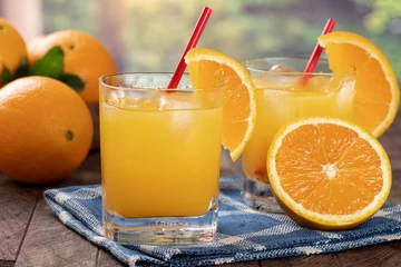 Fotobehang Glass of orange juice with rural summer background © chas53