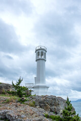 Fototapeta na wymiar The habor lighthouse with sunlight on the seashore.