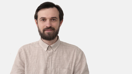 Fototapeta premium Close-up portrait of a handsome smiling young man. Cheerful man isolated on gray background studio shot. Male face model with beard