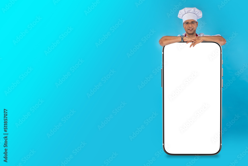 Poster big phone in front of chef cook. man in chef's hat. chef recommends concept. place to showcase app. 