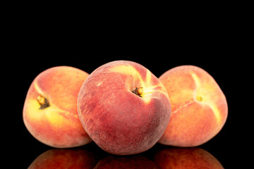 Three sweet organic peaches, close-up, isolated on black background.