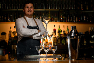 beautiful view of the tower made of empty glasses and a shaker on the bar counter.