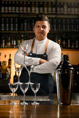 charming view of the tower made of empty glasses and a shaker on the bar counter.