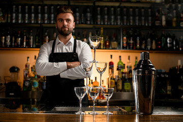 wonderful view of the tower made of empty glasses and a shaker on the bar counter.