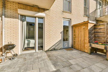 Neat paved patio with sitting area and small garden near wooden fence