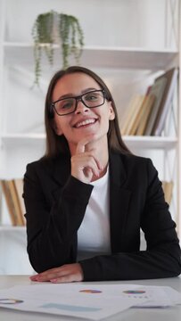 Video interview. Virtual meeting. Corporate webcast. Satisfied curious smiling business woman listening report nodding yes agree at light home office interior vertical.