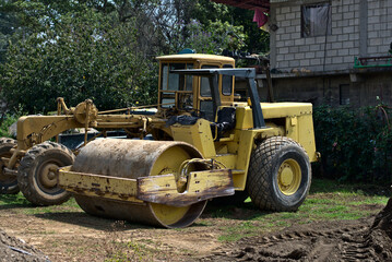 Old yellow road roller in rural field