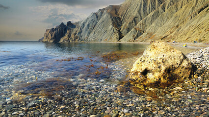 Sea pebbles, filmed on the Crimean Peninsula, Eastern Crimea, near Feodosia, The Karadag mountain range is visible in the distance. 