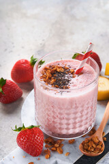 Strawberry smoothie. Vegan smoothie or milkshake from strawberry, banana and mint on white wooden table background. Clean eating, alkaline diet. Top view. Mock up.