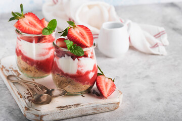 Strawberry Cheesecake. Cheesecake or trifle with strawberry in glass on old gray concrete background table background. Cheesecake without baking. Dessert. New York. Copy space. Food background.