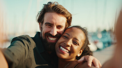 Close up portrait of happy man and smiling woman doing stream on smartphone. Close-up, joyful young interracial couple communicating via video call using mobile phone