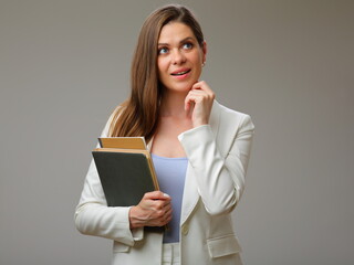 Teacher or student woman thinking and looking away dressed in white suit studio isolated portrait.