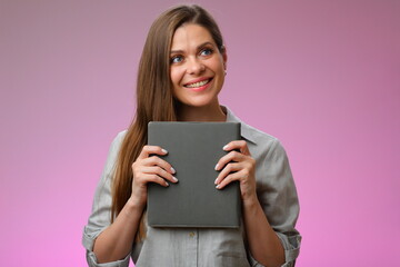 Naklejka premium Happy woman teacher or student girl holding book in front of and looking up, isolated female portrait.