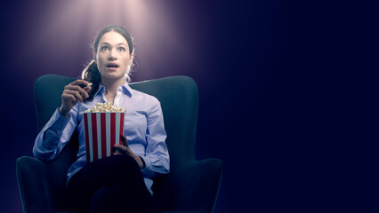 Woman watching movies and eating popcorn