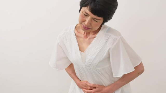 腹痛を感じる中年女性　白背景