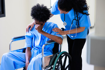 Unhappy lonely depressed and sad feeling. Black man patient siting on wheelchair with black woman...