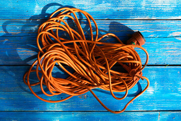 Orange power cord on the blue painted planks.