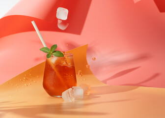Kombucha with mint, iced tea, a refreshing drink in the heat, ice falls into a glass. Bright...