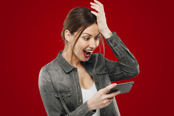 Portrait of shocked amazed girl excited with unbelievable perfect news isolated on red background