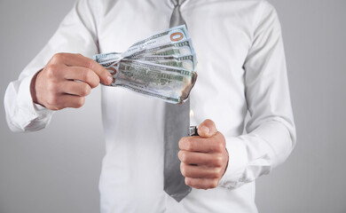 Businessman with a burning money in office.
