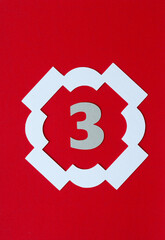 the number 3 frame in white on red paper