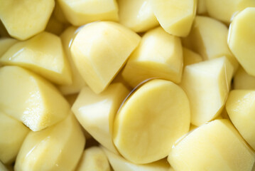 Texture, close up of yellow potatoes in a bowl with water