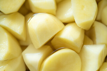 Texture, close up of yellow potatoes in a bowl with water