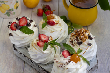 Obraz na płótnie Canvas Pavlova meringue cakes with whipped cream and fresh strawberries, mint leaves. Selective focus.
