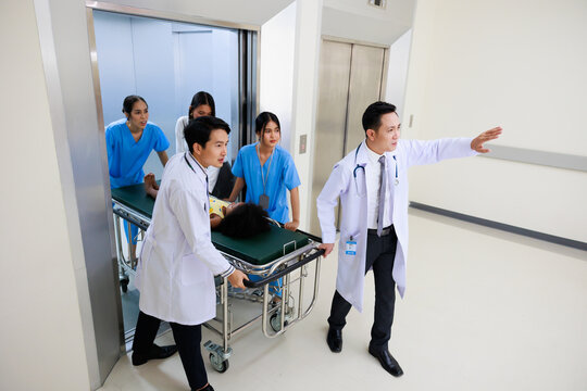 Group of Asian medics or doctors Push Stretcher with Seriously Patient to Operating Room, Emergency Department - Powered by Adobe