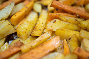 Fried potato and sweet potato wedges with spices background