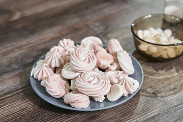 Fototapeta na wymiar beautiful pink meringues on a plate close-up for cake decoration