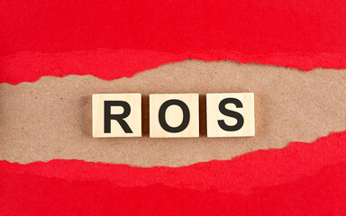 ROS word on wooden cubes on red torn paper , financial concept background