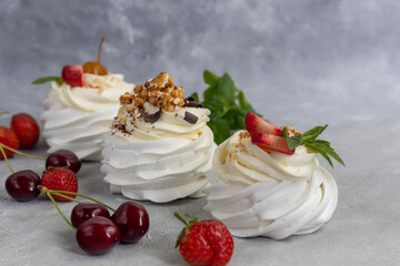 Pavlova meringue cakes with whipped cream and fresh strawberries, mint leaves. Selective focus.