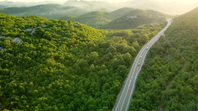 Amazing sunset aerial top drone view of high-speed road between the picturesque mountains. Top down view of picturesque mountain serpentine stretching into the distance. Beautiful nature of Montenegro