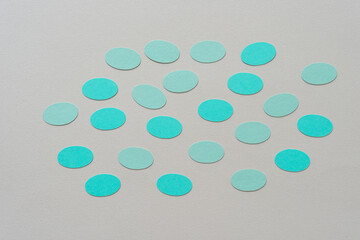 green paper ovals loosely arranged on a beige paper background