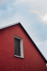 Minimalistic roof of a red house with sky and clouds