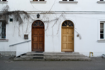 Wooden doors in old white house wall. Poland, Warsaw.