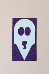 alien mask on purple and beige paper