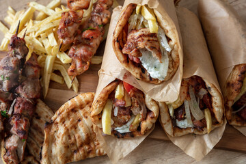 Greek street food, gyro sliced meat pita bread wrap and souvlaki skewer, overhead