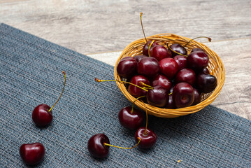 Ripe red cherries in a plate on a wooden background