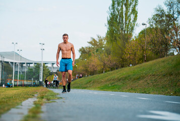 Attractive healthy fitness shirtless male running at the stadium