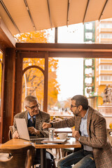 Looking at something on the lap top while discussing it in the cafe