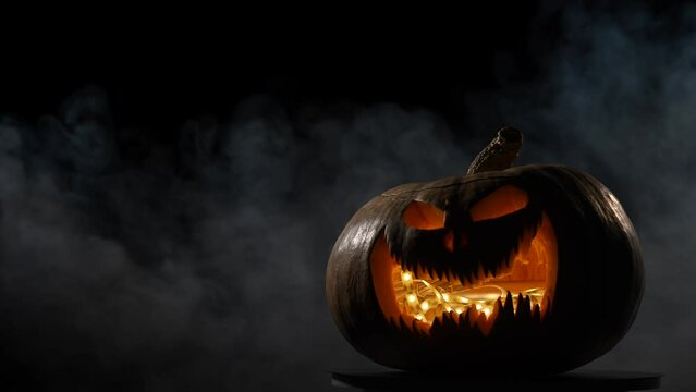 A creepy pumpkin with a carved grimace in the smoke. Jack o lantern in the dark.