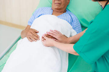 Asian elder male patient sitting on wheelchair. Woman doctor talk with senior patient at ceception medical hospital.