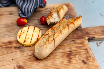 Stück Baguette mit Grillkäse auf dem Schneidebrett