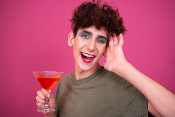 Drag queen drinks a cocktail. Funny guy in make-up.