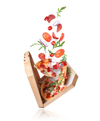 Freshly baked spicy pizza with ingredients in the air on a white background